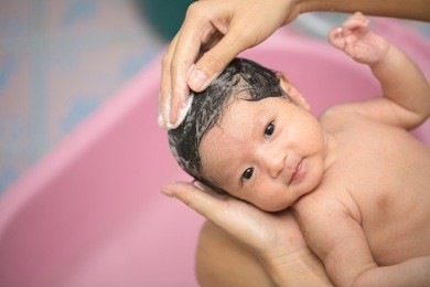 asian new born having a bath by mother