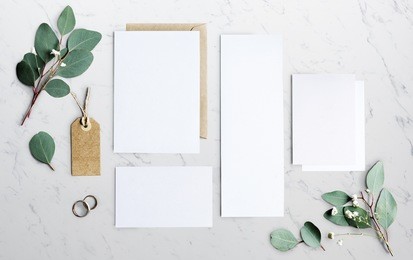 blank papers laying on marble table with leaves decoration