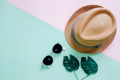 flat lay of minimal accessories items for summer with hat and sunglasses on colorful background