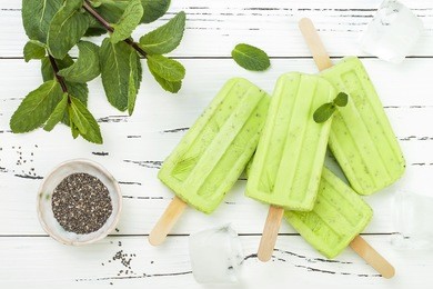 homemade vegan green tea matcha mint coconut milk popsicles - ice pops - paletas with chia seeds on rustic white wooden background