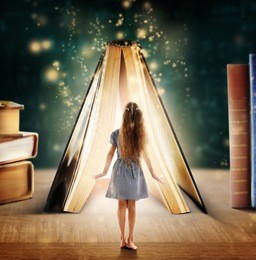 adventure story and fairy tale. tiny girl and book with magic glowing on table