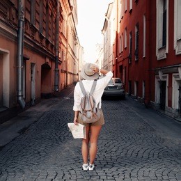 travel guide. young female traveler with backpack and with map on the street. travel concept. adventure