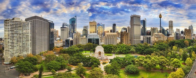 sydney hyde park and cbd cityline on a bright autumn day. colourful trees around anzac memorial and tall towers of the city.