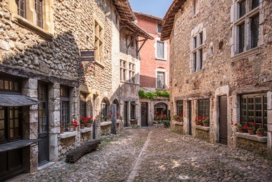beautiful view of scenic narrow alley with historic stone houses and cobbled street in an old town perouge in france.