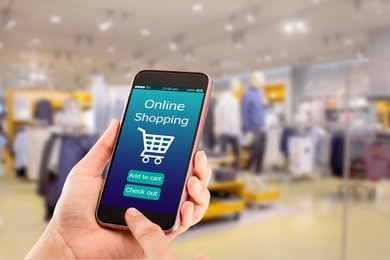 online shopping concept.close-up of hands using touch screen smartphone in department store as background