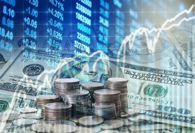 stack of coins and american dollars money over the led display stock market exchange data background, business investment and trading concept