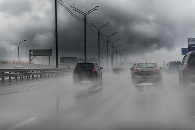 picture of traffic on the freeway during a storm. heavy rain on a road.