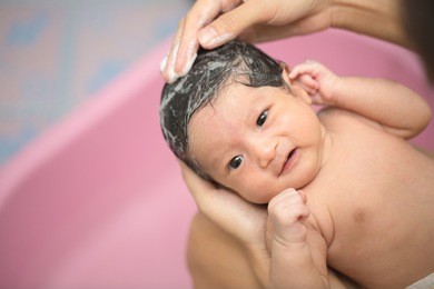 asian new born having a bath by mother