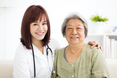  young smiling home caregiver  with senior woman