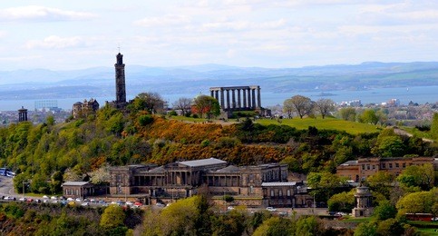 views to calton hill, nelsons monument and the dugald stewart monument at sunset. photo taken from arthur seat in edinburgh.