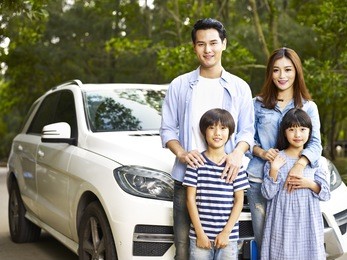 asian family with two children taking a photo during travel by car.