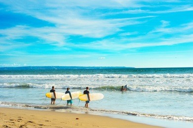 group of surfers ready to surf on the beach. bali island, indonesia