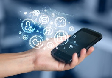 hand holding smartphone with glowing mobile app choices