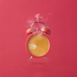 alarm clock as coffee cup over pink background. creative modern still life photography concept