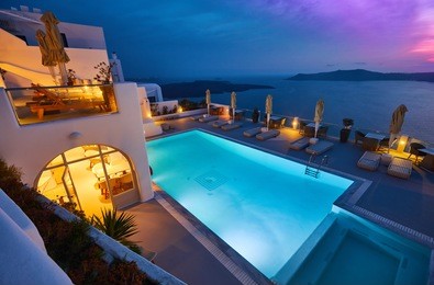 swimming pool on the hotel terrace of fira's town, greece. incredibly romantic sunset on santorini. oia village in the morning light. amazing sunset view with white houses. island lovers