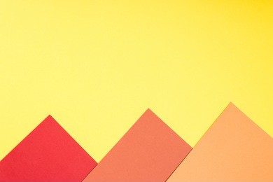 color papers geometry flat composition background with yellow, red, orange and brown tones.