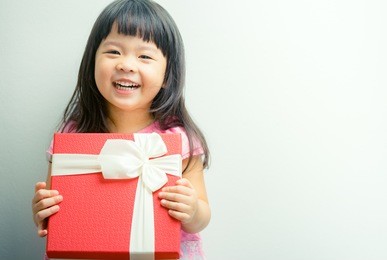 little asian girl smile and holding red gift box on white background.child holding gift box.