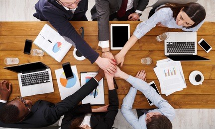 multiethnic team put hands together, connection, teambuilding and alliance concept. people in the office, young businessmen and women unite hands for teamwork and cooperation. top view, overhead