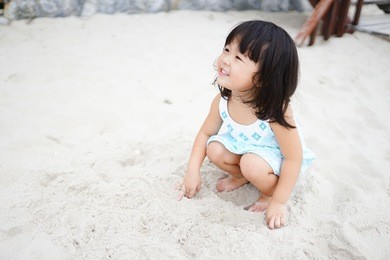 little asian girl wear straw hat playing on the beach with her mother.summer vacation and relax concept.