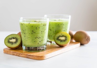 healthy fresh kiwi smoothie in glass - selective focus point
