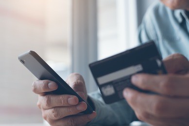 online payment or internet banking,  man makes an online shopping by credit card payment on mobile smart phone, online banking, e commerce, e business, internet of things concept