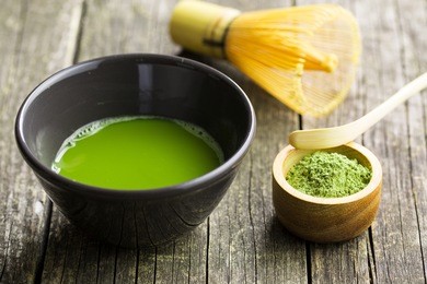 green matcha tea , bamboo whisk, spoon and tea powder.
