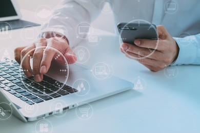 big data analytics with business intelligence (bi) concept. businessman using mobile phone and laptop computer on white desk with vr chart and graph with icon 