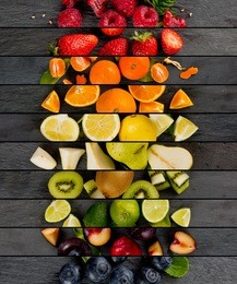 top view of colorful mix stripes with fruit and slices on gray slate surface; healthy eating concept