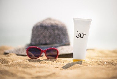 bottle of sunscreen lotion on the sandy beach