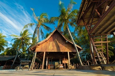 beautiful morning view of a resort on white sandy beach with blue sky and coconut tree in mantanani island, sabah, malaysia