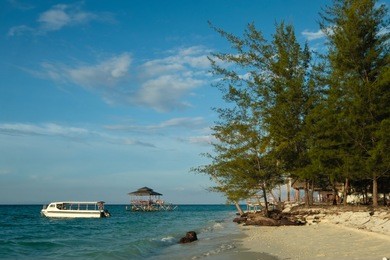 beautiful view of white sandy beach with blue sky and turquoise clear water, and kinabalu mountain at the background view from mantanani island, sabah, malaysia 