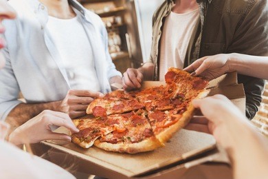 young people partying, eating pizza at home party
