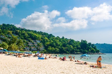 tourists on the kata noi beach - one of the best beaches in phuket, thailand 