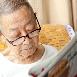 a senior man is reading newspaper