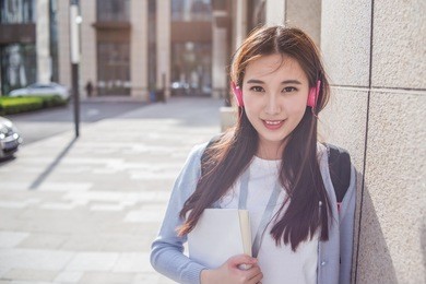 young woman listen music with cup of coffee and book in hands