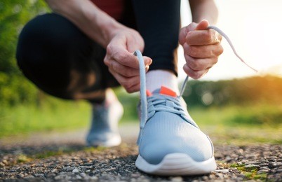 woman runner tying shoelaces outdoor. close up of trail runner tying shoelace. running concept