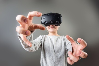 girl wearing virtual reality goggles standing on grey background. vr glasses. 360 degrees. virtual reality headset. vr game. wearing virtual reality goggles. smartphone with vr. virtual reality video.