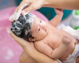 asian new born having a bath by mother