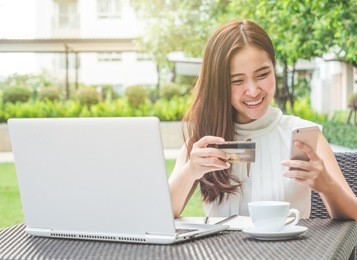 young beautiful asian woman using credit card and laptop for online shopping at outdoor park, smile/fresh and happy feeling in the morning, freelancer businesswoman lifestyle concept