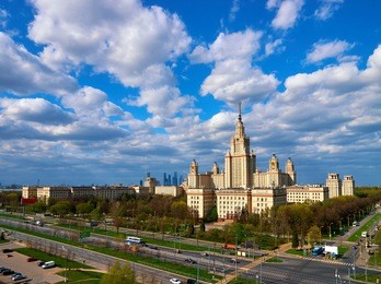 a landscape view of the sunny spring campus of lomonosov moscow state university under blue cloudy sky