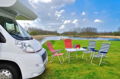 family vacation, rv (camper) travel concept, motorhome trip, table and chairs in holiday campsite
