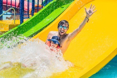 father and son on a water slide in the water park.