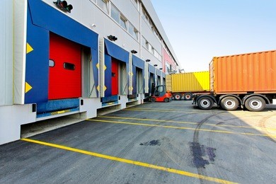 forklift and trucks at cargo dock of warehouse