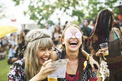group of friends drinking beers enjoying music festival together