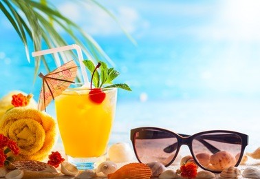 summer concept: fresh exotic cocktail and sunglasses on the beach