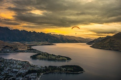 paragliding over queenstown and lake wakaitipu with the remarkables in the background from viewpoint at queenstown skyline, new zealand