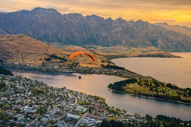 paragliding over queenstown and lake wakaitipu with the remarkables in the background from viewpoint at queenstown skyline, new zealand