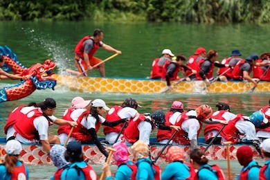scene of a competitive boat racing in the traditional dragon boat festival in taiwan, with view of athletes pulling vigorously on their oars and competing strenuously in colorful dragon boats
