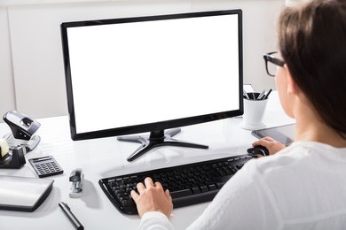 close-up of a businesswoman using computer with blank screen at workplace