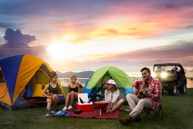 party, camping of asian man and women group, relaxing, sing a song and cooking, with ligh from car and tent